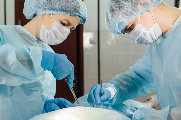Kirurger team som arbetar med övervakning av patient i kirurgisk operationssalen. — Stockfoto