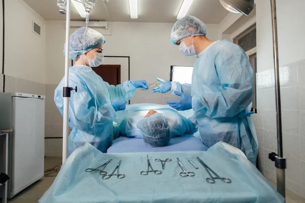 Equipo de cirujanos trabajando con Monitoreo del paciente en quirófano quirúrgico. aumento de senos —  Fotos de Stock