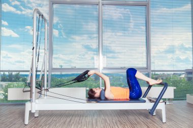 Pilates reformer Egzersiz Egzersizler kadın kapalı spor salonunda