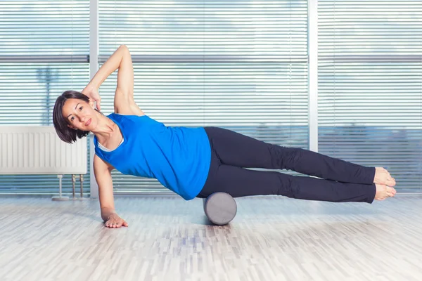 Fitness, spor, eğitim ve yaşam tarzı kavramı - köpük rulo ile katta pilates yapıyor kadın — Stok fotoğraf