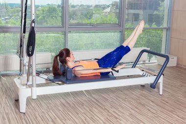 Pilates reformer Egzersiz Egzersizler kadın kapalı spor salonunda