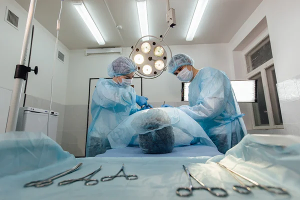 Equipo de cirujanos trabajando con monitorización del paciente en quirófano . —  Fotos de Stock