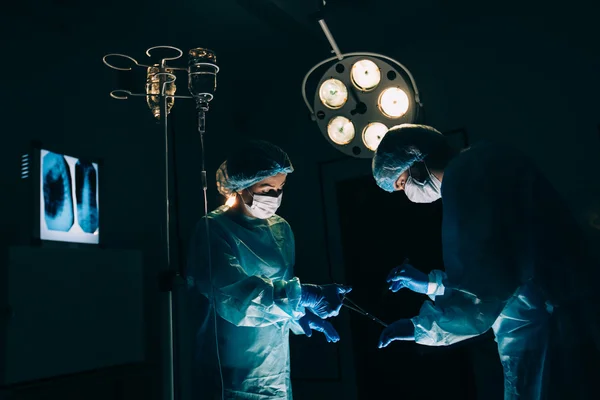 Équipe de chirurgiens travaillant avec Surveillance du patient en salle d'opération chirurgicale. augmentation mammaire — Photo