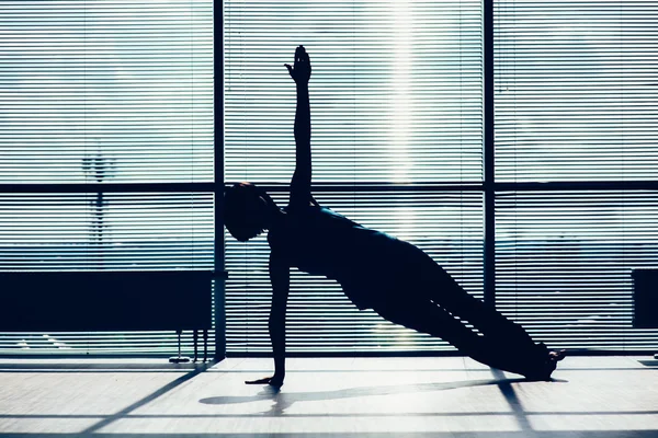 Fitness, sport, training and people concept - smiling woman doing abdominal exercises on mat in gym contour of the body against the window — Stock Photo, Image