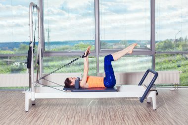 Pilates reformer Egzersiz Egzersizler kadın kapalı spor salonunda