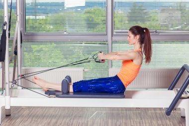 Pilates reformer Egzersiz Egzersizler kadın kapalı spor salonunda