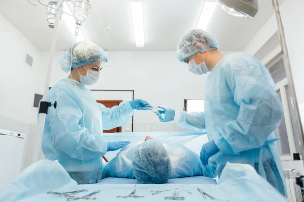 Equipe de Cirurgiões que trabalha com Monitoramento do paciente em centro cirúrgico. aumento da mama . — Fotografia de Stock