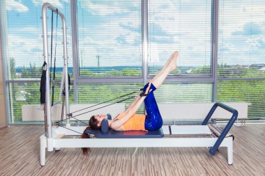 Pilates reformer Egzersiz Egzersizler kadın kapalı spor salonunda