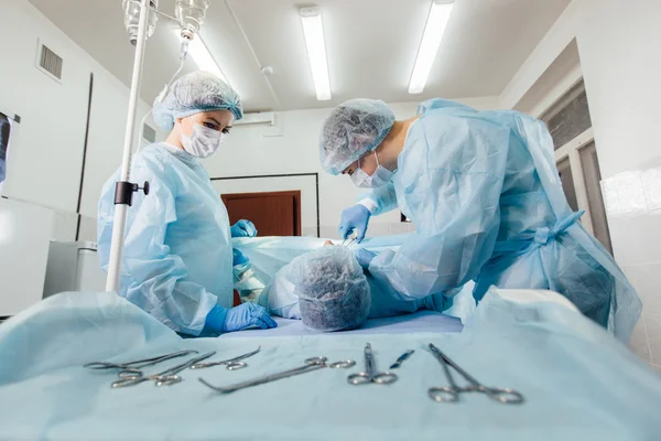 Equipe de Cirurgiões que trabalha com Monitoramento do paciente em centro cirúrgico. aumento da mama — Fotografia de Stock