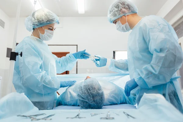 Équipe de chirurgiens travaillant avec Surveillance du patient en salle d'opération chirurgicale. augmentation mammaire . — Photo