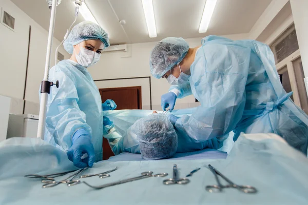 Χειρουργοί ομάδα εργασίας με παρακολούθηση του ασθενούς στο χειρουργικό χειρουργείο. αυξητική στήθους — Φωτογραφία Αρχείου