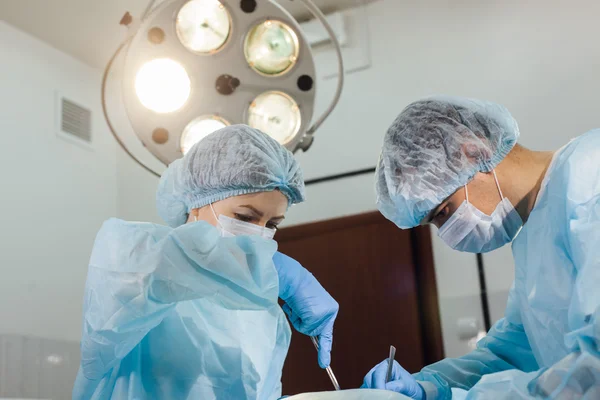 Equipe de Cirurgiões que trabalha com Monitoramento do paciente em sala cirúrgica . — Fotografia de Stock