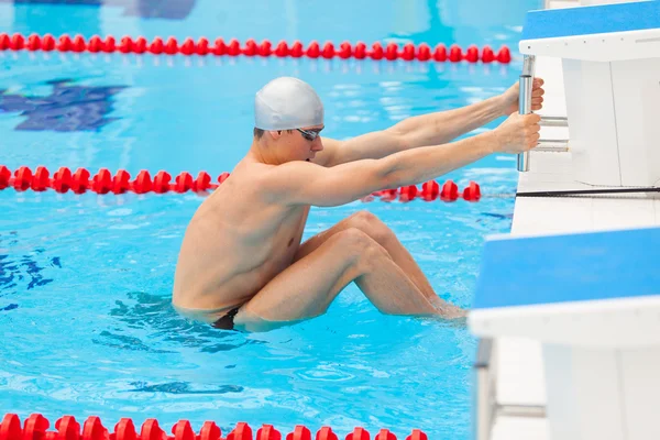 Jeune homme dans une piscine - aller pour commencer à nager. dos pendant — Photo