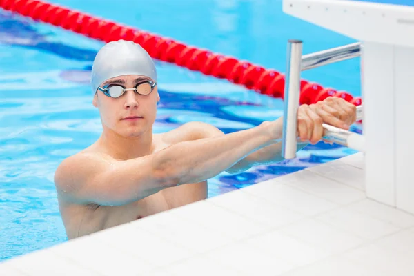 Jonge zwemmer staande in blauwe water — Stockfoto