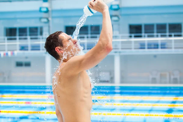 Homem fitness corredor beber e espirrar água em seu rosto . — Fotografia de Stock