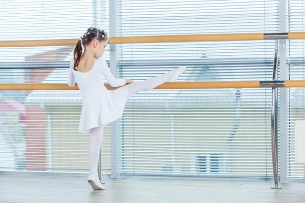 Uma bailarina. Adorável criança dançando balé clássico em um estúdio branco . — Fotografia de Stock