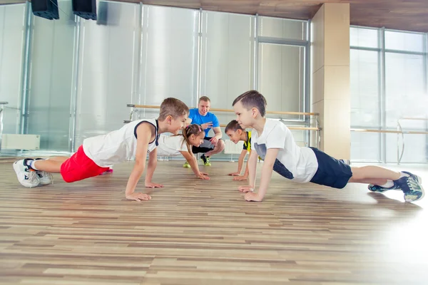 Glada sportiga barn i gym. — Stockfoto