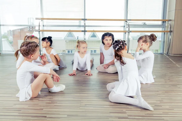 Grupp av sju små ballerinor sitter på golvet. De är god vän och fantastiska dans artister — Stockfoto