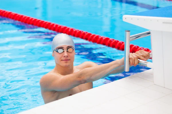 Il giovane in una piscina - va per iniziare a nuotare. dorso durante — Foto Stock