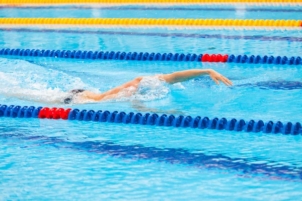 Man zwemmer crawl in blauwe water zwemmen. — Stockfoto