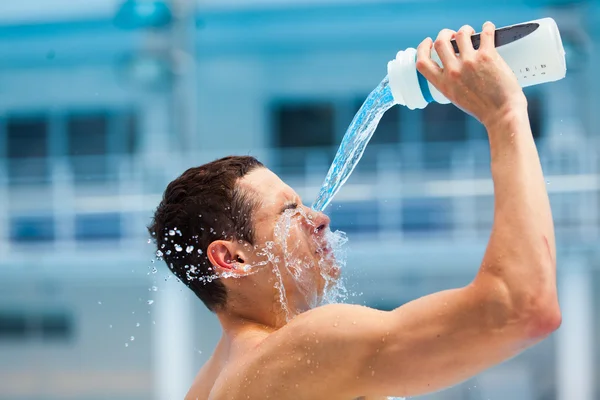 Man fitness runner drinking and splashing water in her face. — Stock Photo, Image