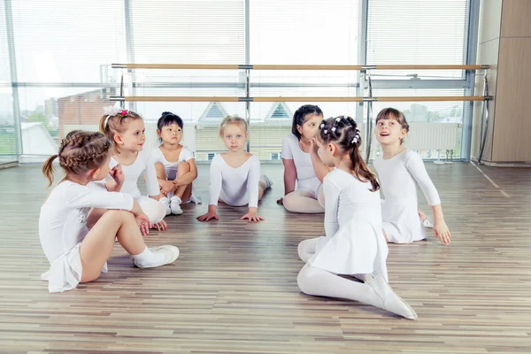 Grupo de sete pequenas bailarinas sentadas no chão. Eles são bons amigos e artistas de dança incríveis — Fotografia de Stock