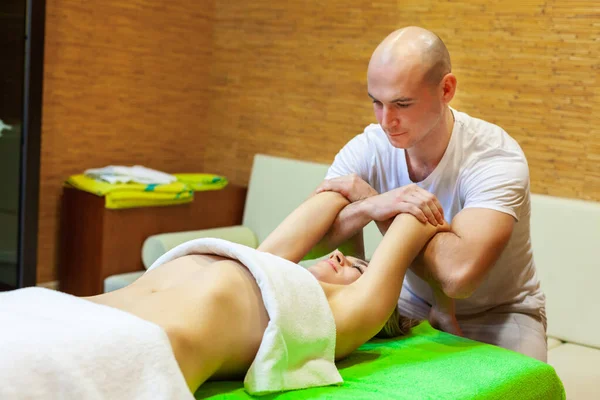 Masseur works on woman arms doing traditional Thai massage on female body in the spa salon. Beauty treatment concept — Stock Photo, Image