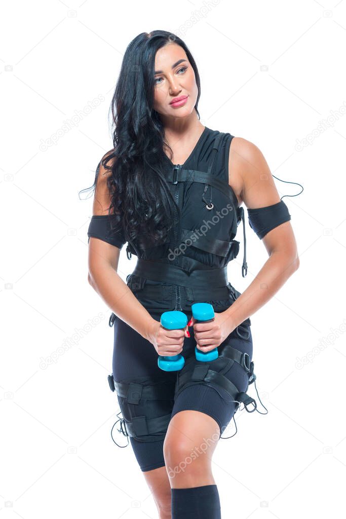 A young athletic woman in an EMS suit exercising with dumbbells on an isolated white background. EMS training. Electro muscular stimulation machine.