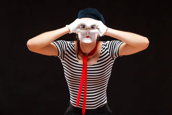 Portrait d'un artiste de mime masculin se produisant, isolé sur fond noir. L'homme plie les mains comme s'il regardait à travers des jumelles — Photo