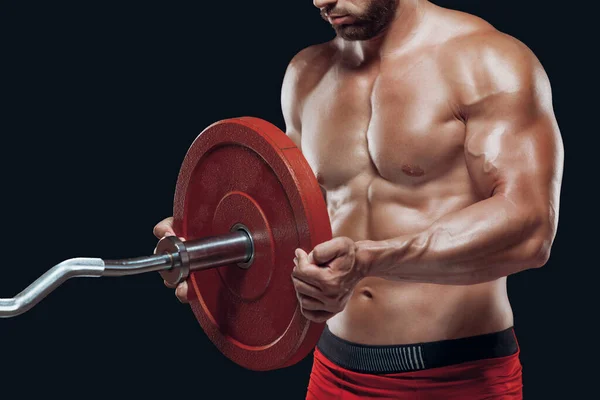 Close-up van een mannelijke atleet zetten een schijf op een lange halter geïsoleerd op zwarte achtergrond — Stockfoto