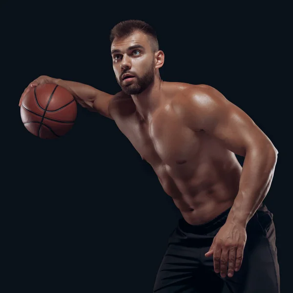 黒の背景に孤立したバスケットボールをしている非常に筋肉質の裸の男の肖像 — ストック写真