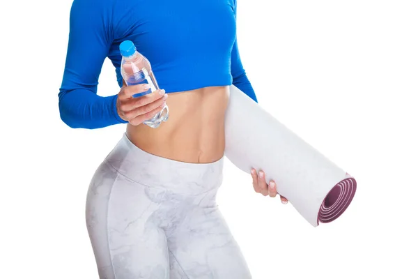 하얀 배경에 고립 된 손에 광천수 한 병과 매트를 들고 있는 매력적 인 스포츠 여성의 모습을 가까이서 찍은 사진 — 스톡 사진
