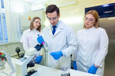 Bir grup bilim adamı ileri teknolojiyi kullanarak bir bilimsel laboratuvarda araştırma yapıyor. COVID-19. COVID Coronavirüs