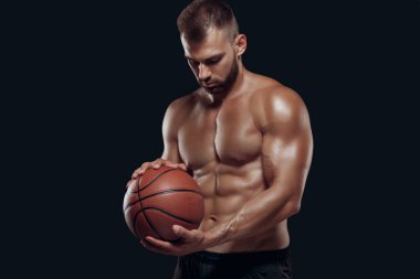 Siyah arka planda basketbol oynayan kaslı çıplak bir adamın portresi.