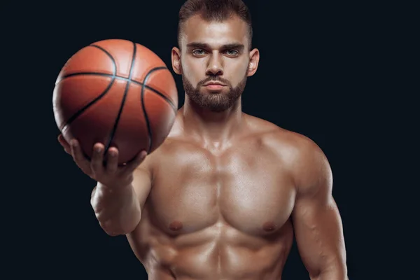 黒の背景に隔離された筋肉質の男性選手の手の中にバスケットボールのクローズアップ — ストック写真