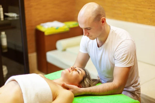 Terapeuta profissional dando massagem no pescoço para uma bela jovem mulher no spa de beleza — Fotografia de Stock