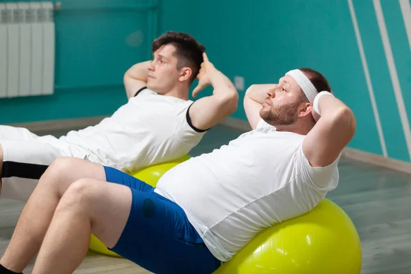 Moe dikke man ligt op een fitness bal training tijdens de groep fitness klassen. Overgewicht — Stockfoto