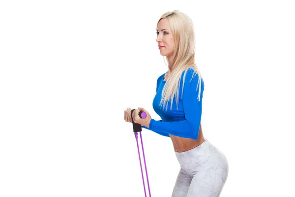 Vista lateral da menina fitness loira se exercitando com expansor de fitness isolado no fundo branco — Fotografia de Stock