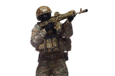 Ordu mensubu kamuflaj ve tam teçhizatlı, miğfer, gözlük ve kar maskesi takan, makineli tüfek tutan, nişan alan ve ateş etmeye hazırlanan, beyaz arka planda izole edilmiş asker görüntüsü.