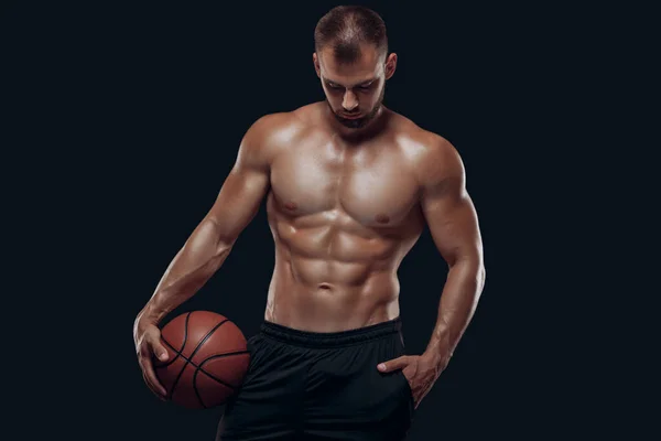 Портрет дуже мускулистого голого чоловіка, який грає в баскетбол ізольовано на чорному тлі — стокове фото