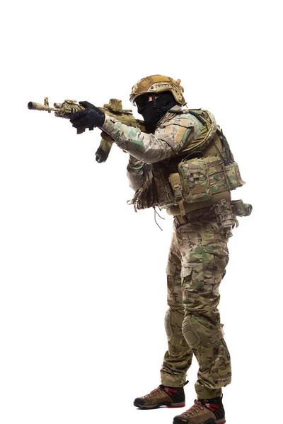 Retrato de comprimento total do soldado em munição de combate em chapéu duro e óculos com uma arma equipada com visão de colimador está apontando para o inimigo pronto para atirar para matar isolado no fundo branco — Fotografia de Stock