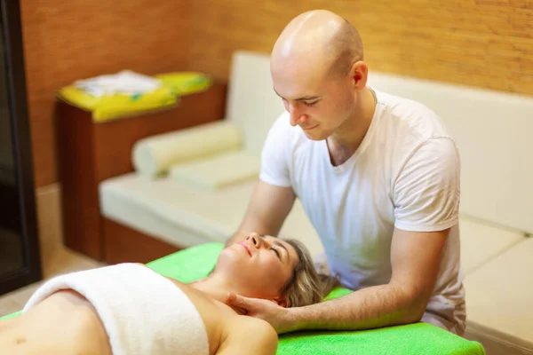 Profesjonalny terapeuta robi masaż szyi pięknej młodej kobiecie w spa — Zdjęcie stockowe