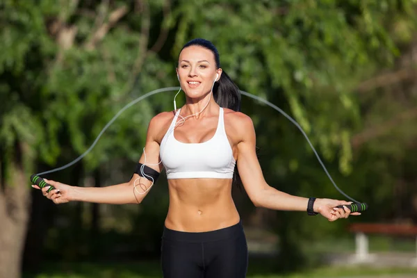 Deporte, actividad. Mujer linda con saltar la cuerda — Foto de Stock