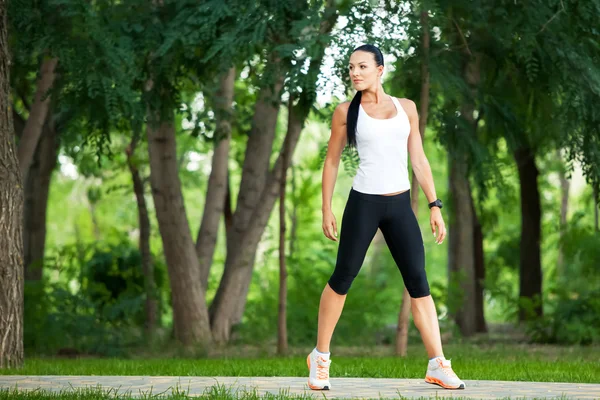 Young athletic woman standing in a park — Stock Photo, Image