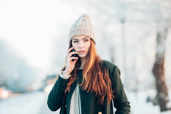 Молода жінка в зимовому парку говорить мобільний телефон, смс — стокове фото