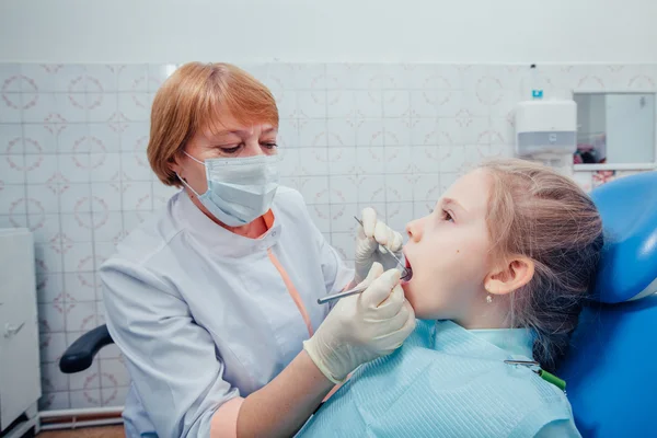 Niña sentada en el consultorio de dentistas —  Fotos de Stock