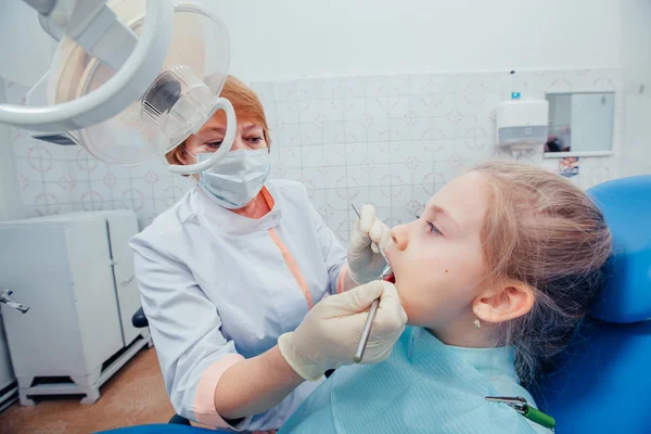 Niña sentada en el consultorio de dentistas — Foto de Stock