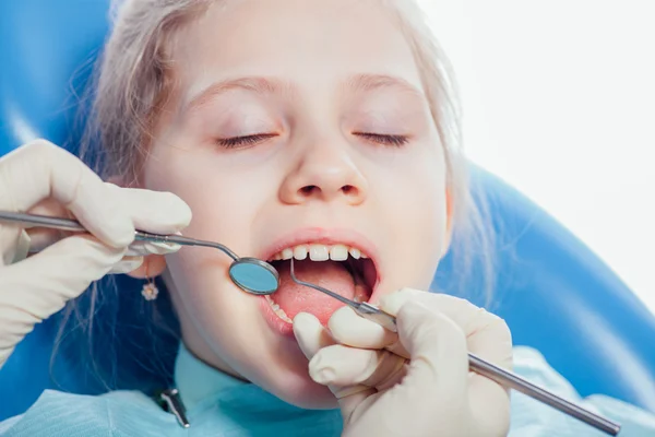 Kleines Mädchen sitzt in der Zahnarztpraxis — Stockfoto