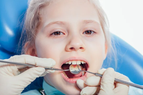 Kleines Mädchen sitzt in der Zahnarztpraxis — Stockfoto