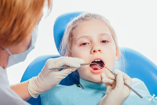 Kleines Mädchen sitzt in der Zahnarztpraxis — Stockfoto